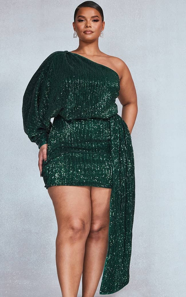 model posing in sparkly green one shoulder dress
