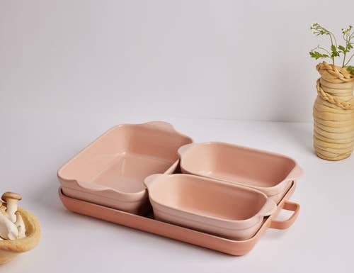 the set in peach stacked together with three different size baking dishes on the oven pan
