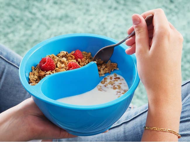 a product shot of someone holding the cereal bowl where you can see the cereal and milk are separate