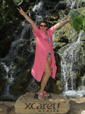 Person successful a casual formation outfit poses with arms raised adjacent a waterfall successful Xcaret, Mexico