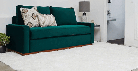 a green velvet sofa pulling out into a queen sized mattress