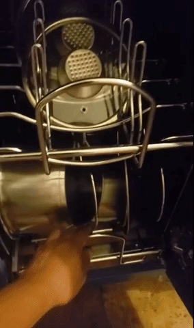 Reviewer video of person pulling out silver wire shelf with pots and pans in dividers inside cabinet