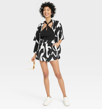 a model wearing the high-rise shorts featuring an abstract white and black print 