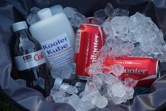 A small rectangular ice pack in a cooler full of ice and soda cans 