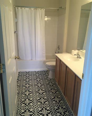 a reviewer photo of the same bathroom with the black and white tile decals applied 