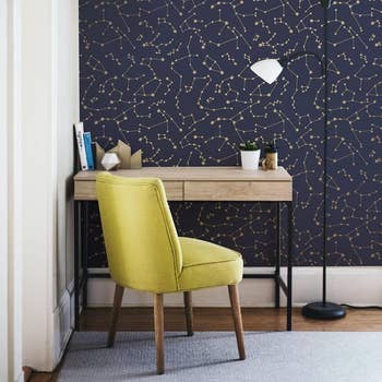 the navy constellation peel and stick wallpaper behind a desk