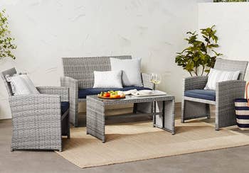 the gray patio set with blue cushions and additional throw pillows