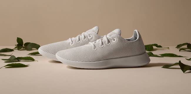 White mesh sneakers displayed with greenish leaves, featured successful a buying article