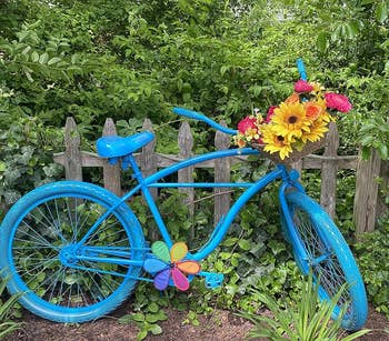a bicycle planter that's been given a blue coat