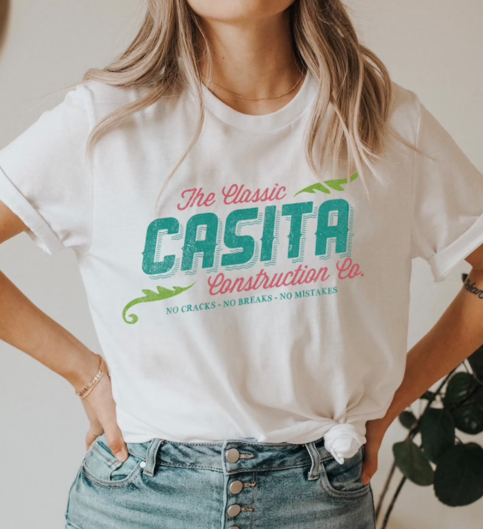 a model in a white tee with pink and teal writing that says 