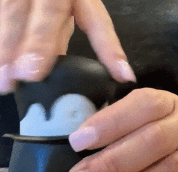 A reviewer twisting a vampire shaped garlic crusher and showing the garlic inside 