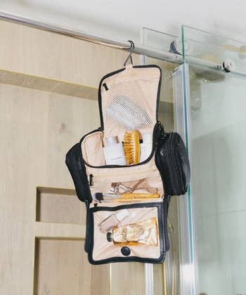 Hanging toiletry container  with antithetic  compartments, holding grooming products and accessories, displayed successful  a bath  setting
