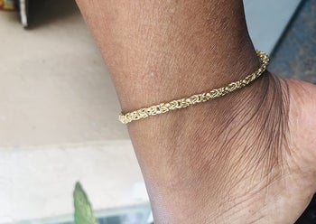 Reviewer wearing gold ankle bracelet