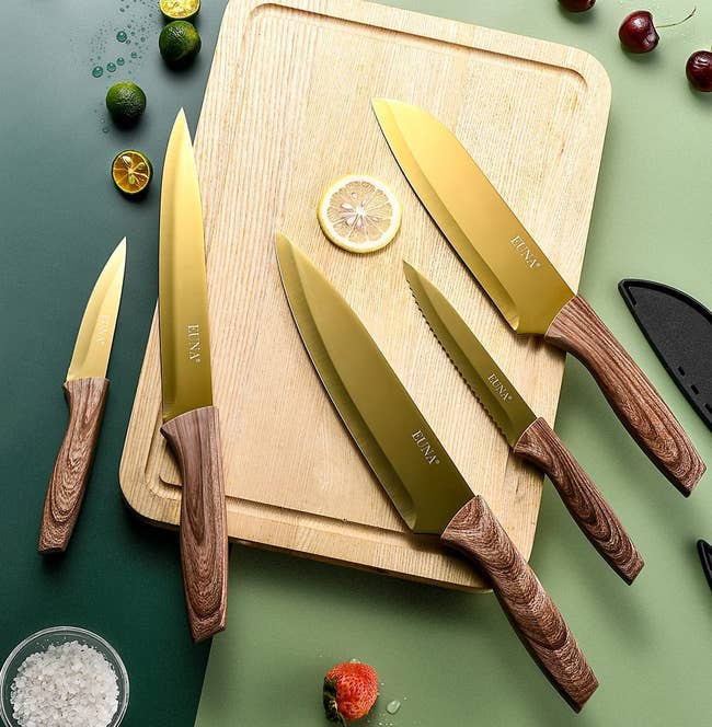 the gold knife set on a cutting board surrounded by various ingredients