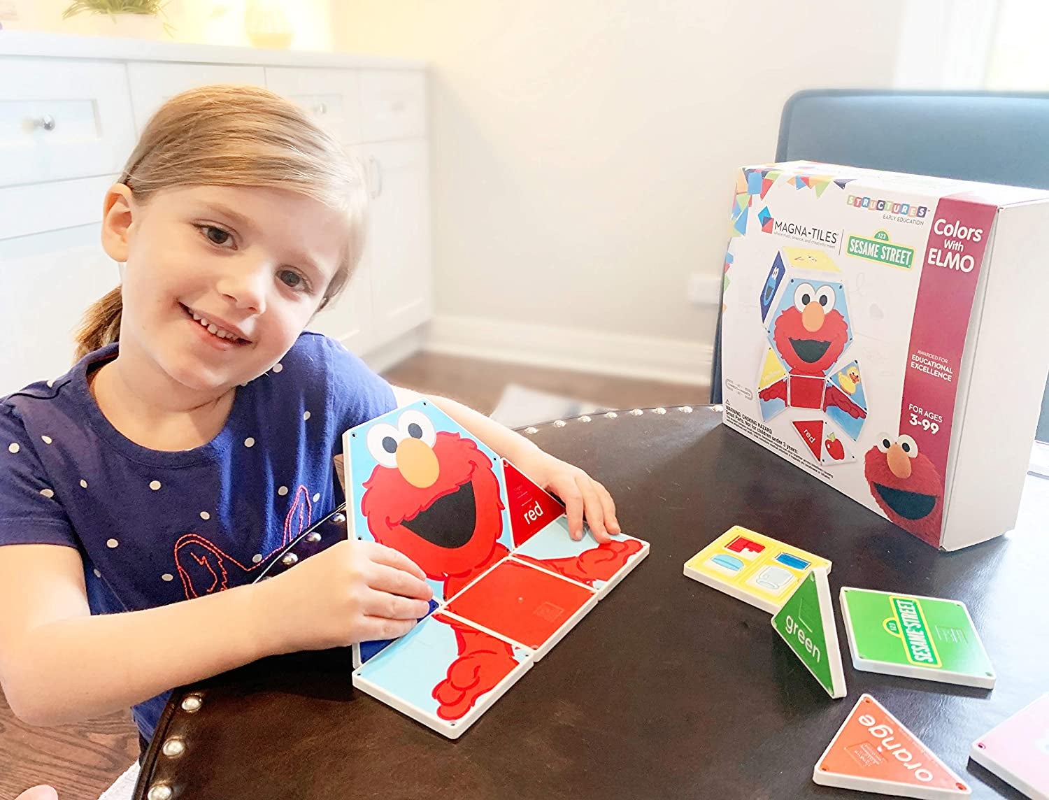 Child model playing with Elmo Magnatile set