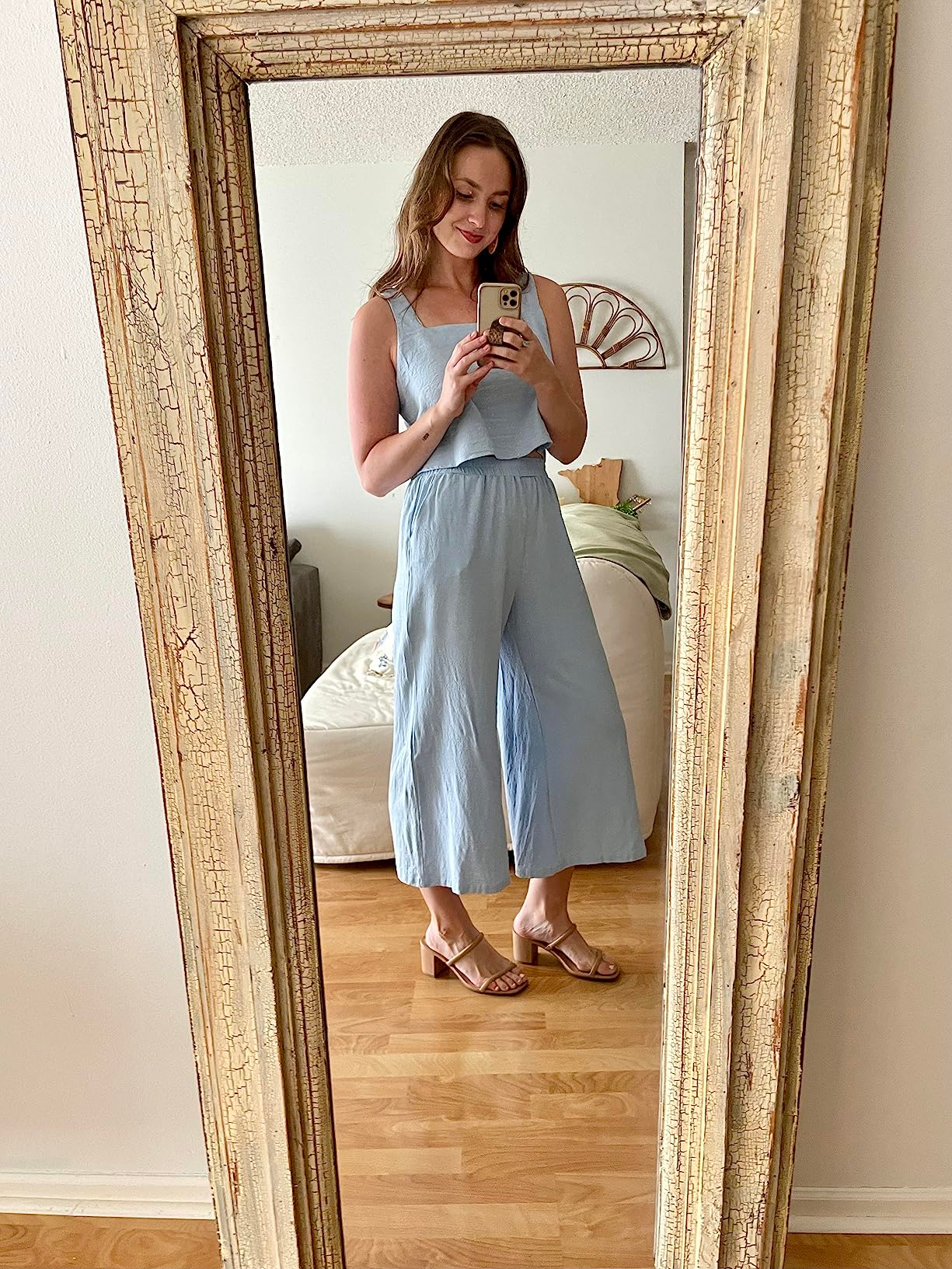 Person successful  a light, sleeveless jumpsuit and sandals takes a reflector  selfie successful  a cozy chamber  setting