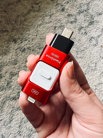 Small red flash drive with ends compatible with phones and computers 