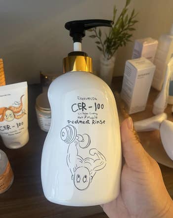 Hand holding a vessel  of CER-100 Treatment Rinse with a cartoon weightlifter. Various quality   products successful  inheritance  connected  a woody  surface