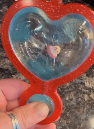 Heart-shaped toy with spinning inner section featuring a small heart