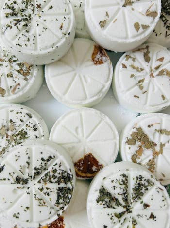 Close-up of circular  bath bombs with pressed herbs and petals, showcasing earthy  skincare products for a buying  feature
