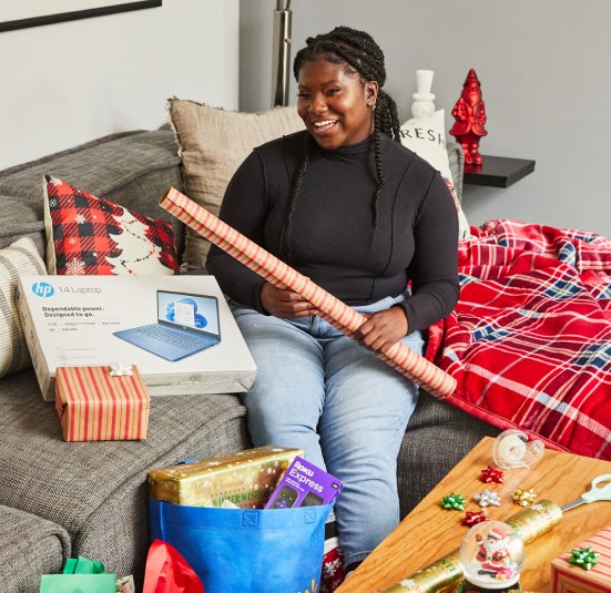Elise sits on couch to wrap presents