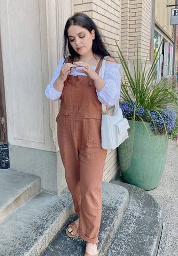 a reviewer wearing the overalls in terracotta