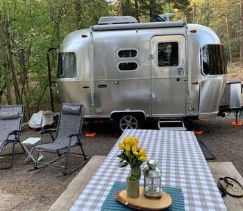 reviewer photo of the beige and white tablecloth on a picnic table in front of an airstream