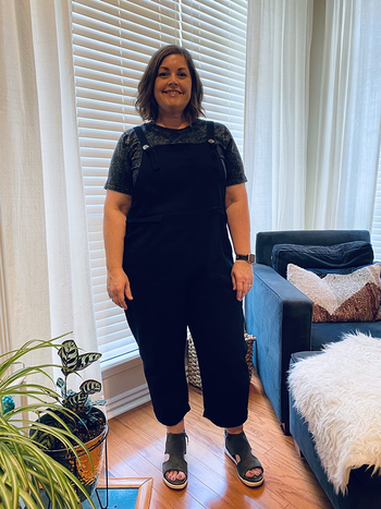 reviewer in black cropped overalls