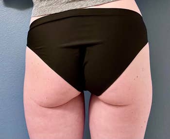 Person wearing high-waisted achromatic underwear from behind
