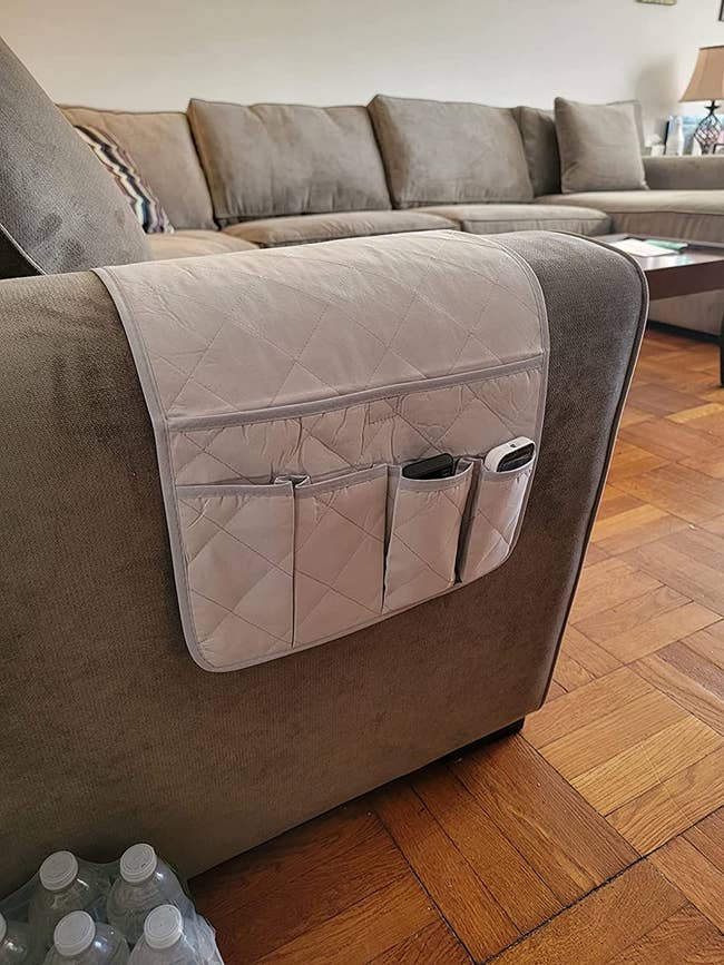 A remote control caddy over the arm of a sofa