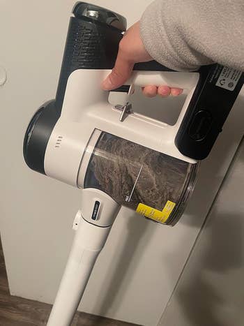 another reviewer holding their vacuum in the compact handheld form