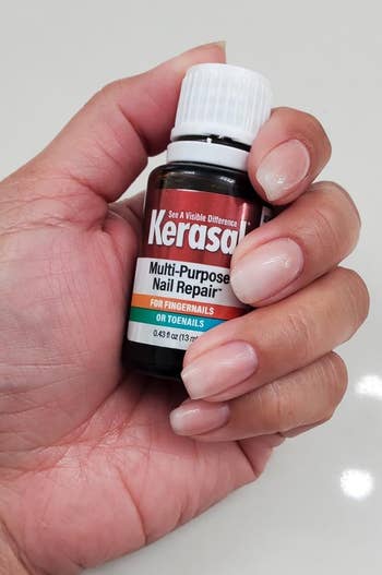 Hand holding a vessel of Kerasal Multi-Purpose Nail Repair
