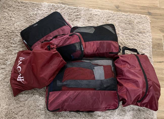 a reviewer photo of the eight-piece set in burgundy all packed up with clothes and shoes 