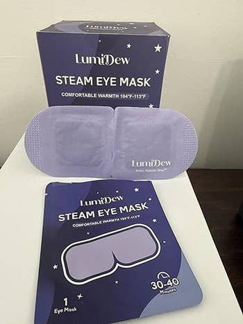 LumiDew Steam Eye Mask packaging displayed, showcasing a azygous oculus mask. The container highlights its warmth and comfortableness for relaxation