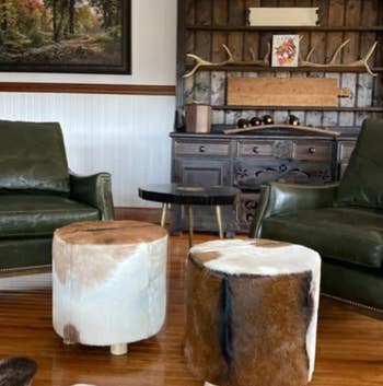 reviewer photo of two genuine cowhide leather round ottomans