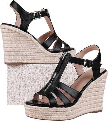 Black strappy level    wedge sandals with buckle and zipper detail, displayed connected  a textured block