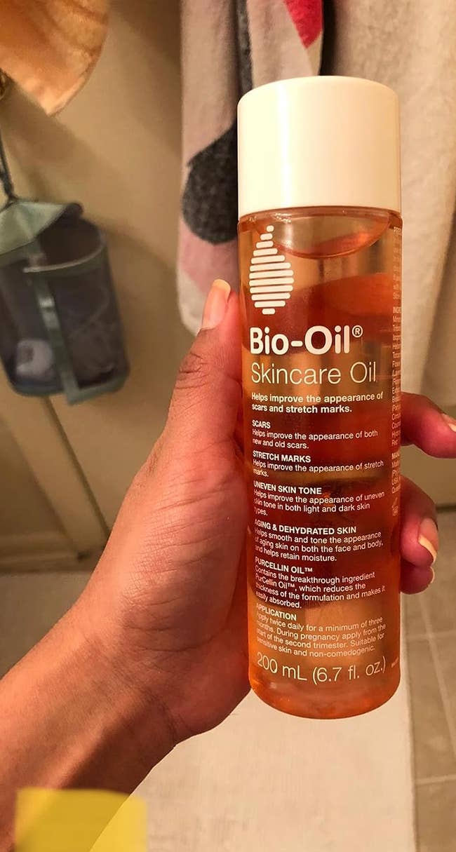 reviewer holding the bottle of bio oil
