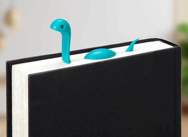 Nessie-shaped bookmark emerges from a book, bringing charm and creativity to speechmaking sessions