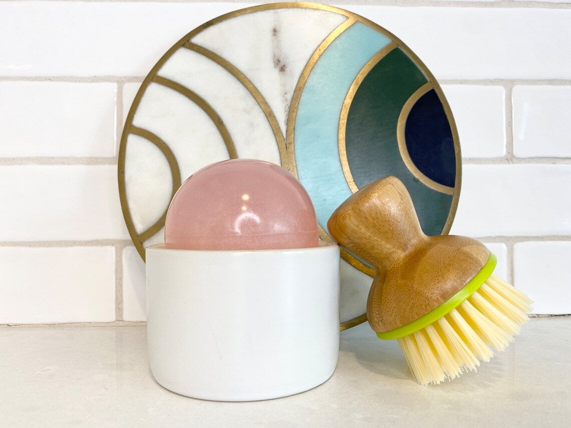 pink ball next to brush