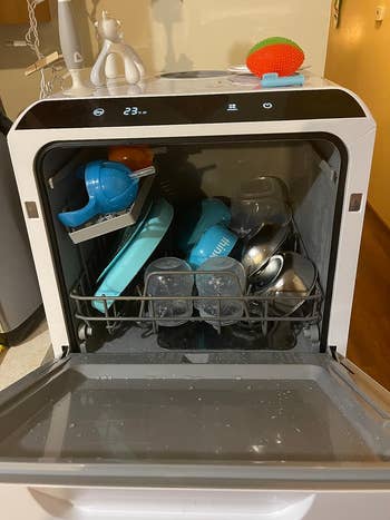 same reviewer with door open showing all the dishes inside the countertop dishwasher