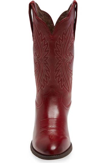 Front presumption    of a western-style reddish  leather cowboy footwear  with intricate stitching