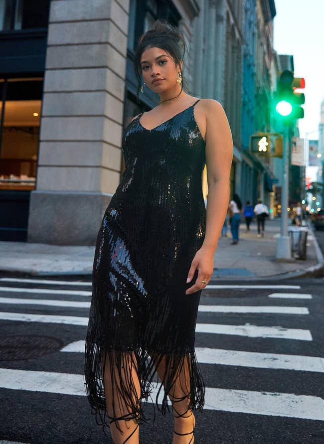 model wearing midi dress with fringe and black sequins