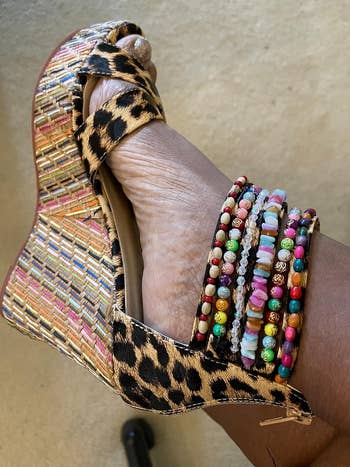 Wedge sandal with a woven level    and leopard people     straps, adorned with colorful beaded ankle bracelets