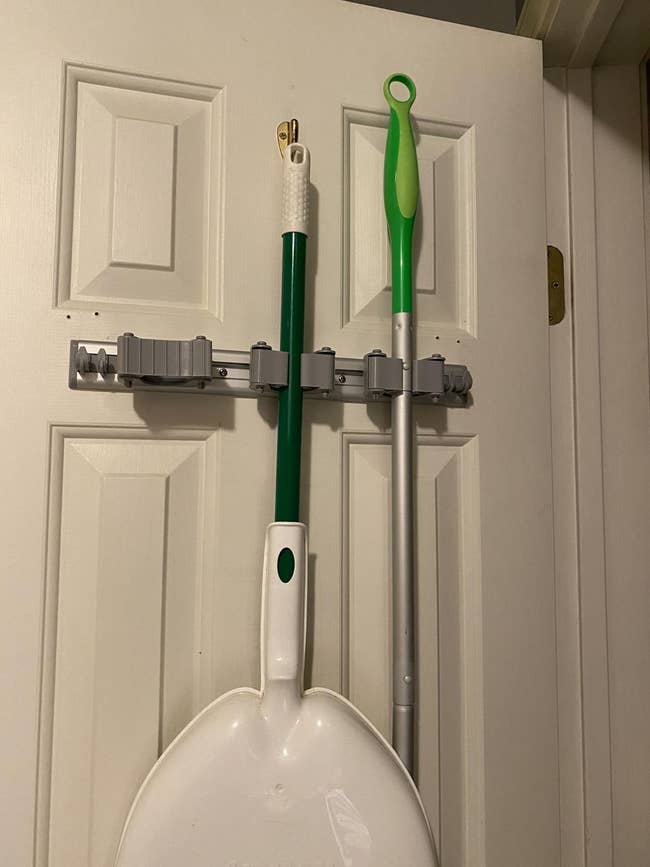 reviewer image of a shovel and mop hanging from the wall-mounted rack