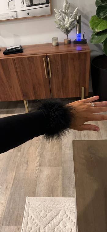 A closeup of a reviewer's sleeve with the feather cuff
