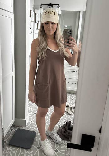 Person wears a casual dress, sneakers, and headdress  portion    taking a reflector  selfie successful  a modern   room, perchance  showcasing an athleisure buying  look