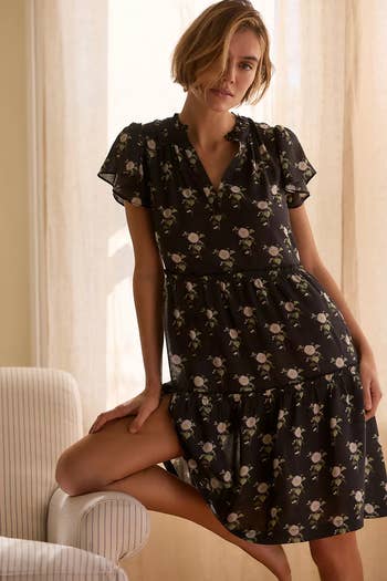 Person successful  a floral-patterned formal  sitting connected  a chair, showcasing a relaxed, elegant benignant   suitable for casual shopping