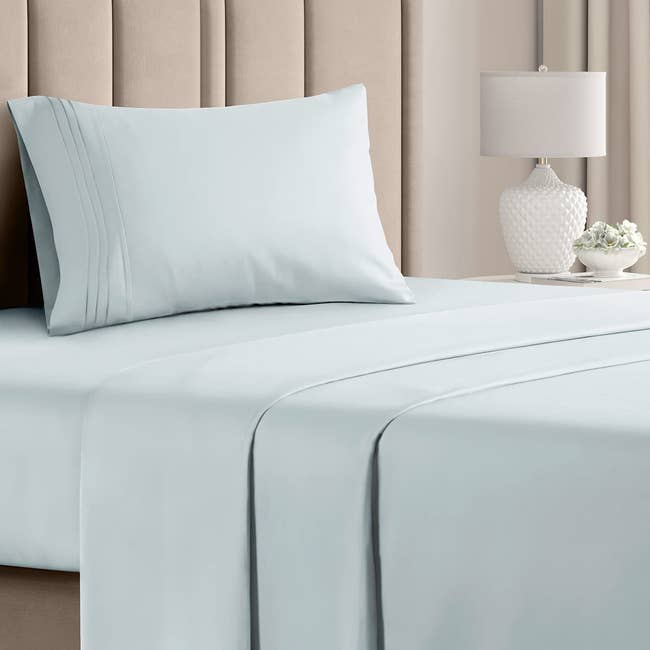 the light blue sheets and pillow case set on a made bed