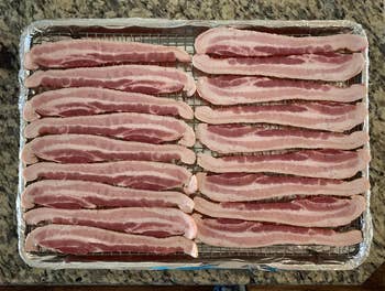 reviewer photo of an entire package of bacon (18 pieces) on the baking sheet