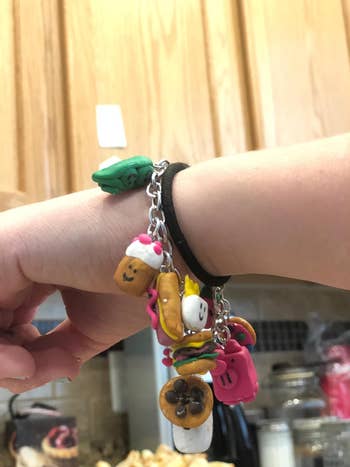 Bracelet with cute, tiny  charms shaped similar  nutrient  items specified  arsenic  crystal  cream, fruit, and sweets connected  a person's wrist